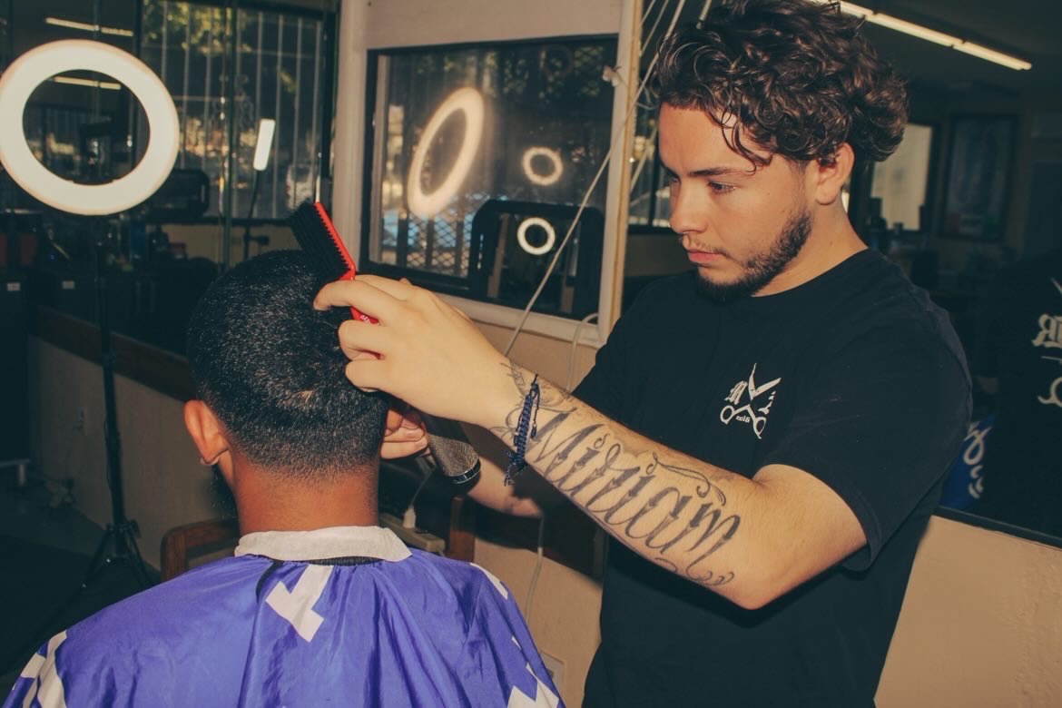 Barber carefully blending a client’s haircut inside Tepa Barbershop